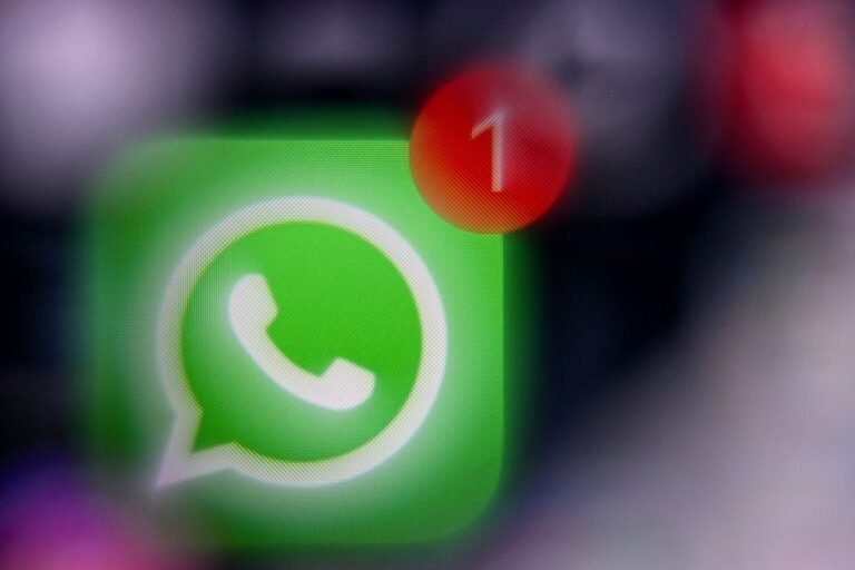 WhatsApp scam warning with mobile phone